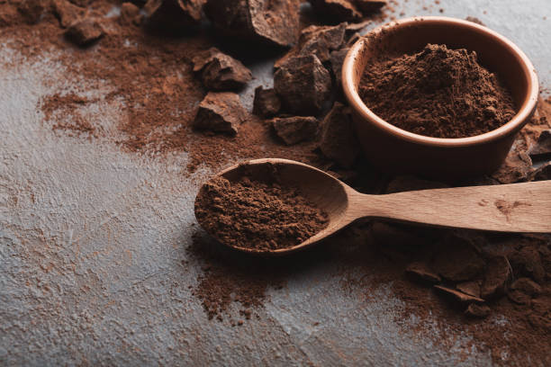 Crushed chocolate pieces and cocoa on gray background