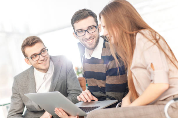 istock friendly business team working on laptop and discussing business matters 961784384