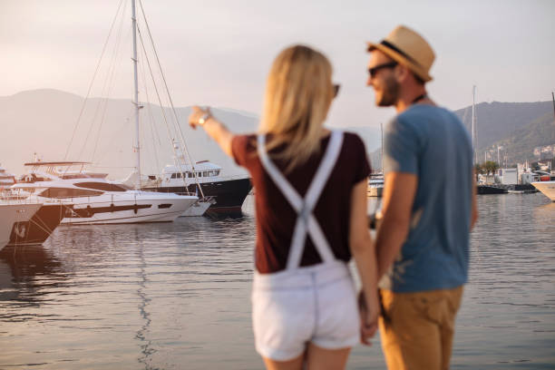 istock Couple on vacation looking at sailboats 961784924