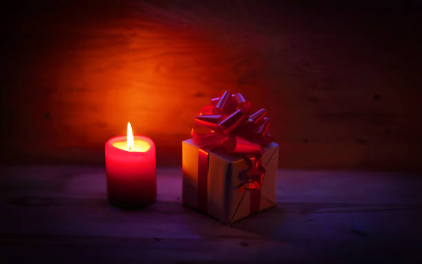 istock two candles and Christmas gift on holiday background 961785024
