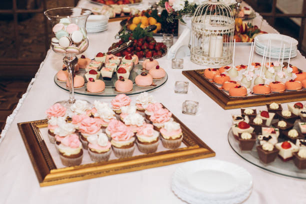 istock delicious candy,sweets,cupcakes,pops decorated with flowers on table at wedding reception. candy bar. tasty pink sweets for celebrations events and showers. luxury stylish catering 961794848