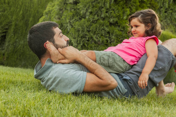 Baby girl playing with daddy outside. Family lifestyle. Summer time stock photo