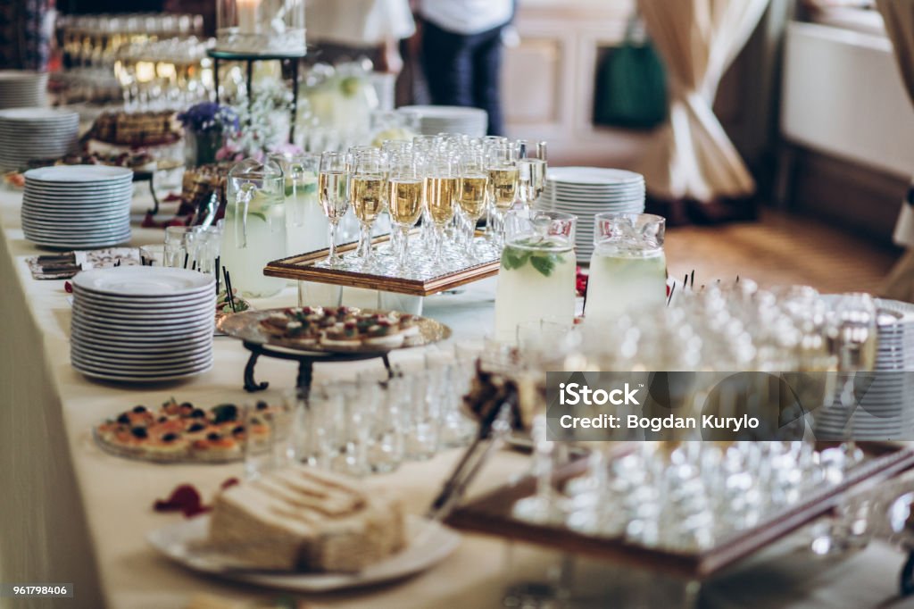 elegantes copas de champán y aperitivos de comida en la mesa en la recepción de la boda. catering en fiestas de lujo. servicio de alimentos y bebidas en el concepto de eventos - Foto de stock de Acontecimiento libre de derechos