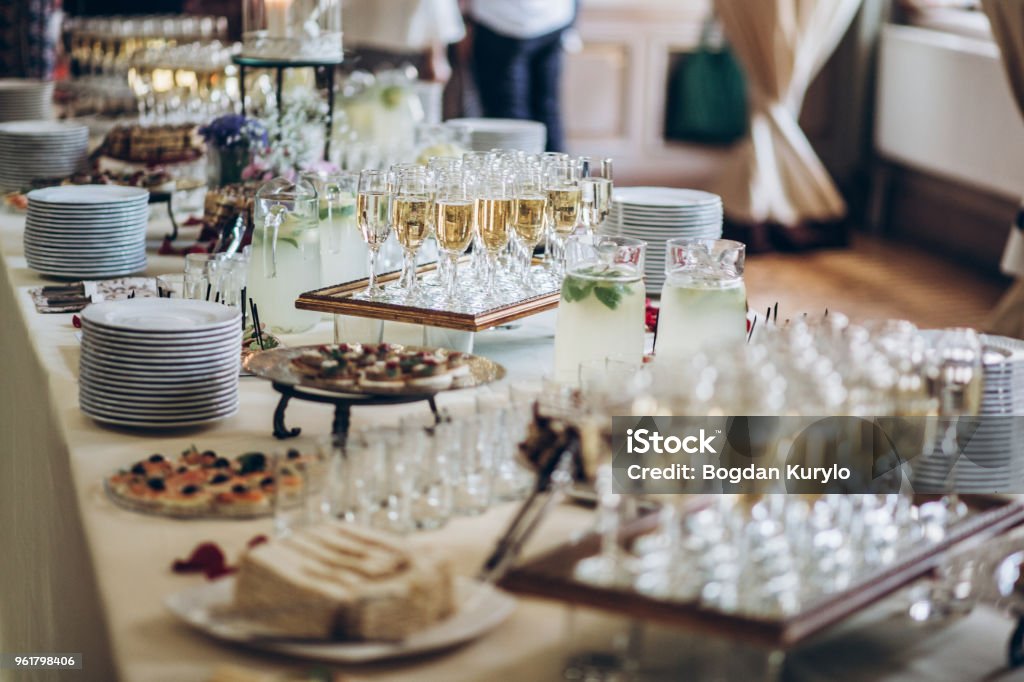 stylish champagne glasses and food  appetizers on table at wedding reception. luxury catering at celebrations. serving food and drinks at events concept Event Stock Photo