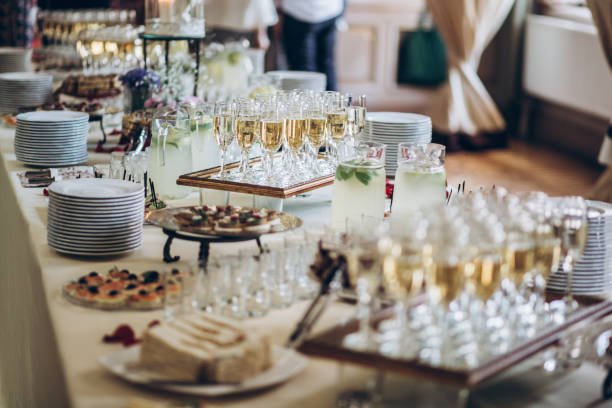 stylish champagne glasses and food  appetizers on table at wedding reception. luxury catering at celebrations. serving food and drinks at events concept stock photo