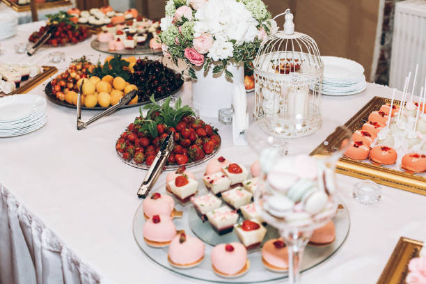 istock delicious candy,sweets,cupcakes,pops decorated with flowers on table at wedding reception. candy bar. tasty pink sweets for celebrations events and showers. luxury stylish catering 961798916