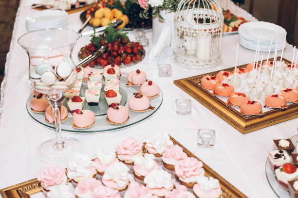 istock delicious candy,sweets,cupcakes,pops decorated with flowers on table at wedding reception. candy bar. tasty pink sweets for celebrations events and showers. luxury stylish catering 961799298