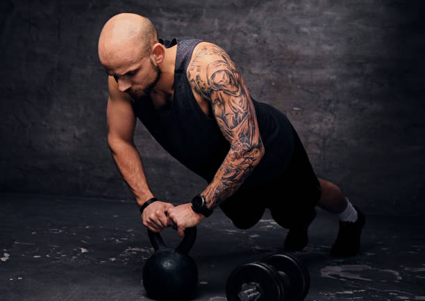 istock Shaved head sporty male doing push ups on Kettlebell. 961803482