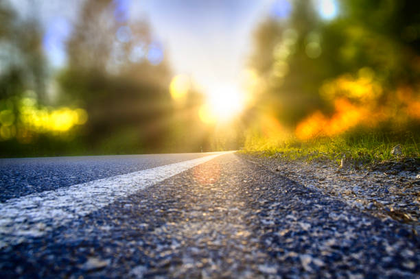 A new beginning into a sunny future Street in backlight with bokeh, lensflares and sunbeams starting line stock pictures, royalty-free photos & images