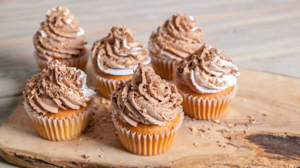 istock Vanilla cupcakes with chocolate cream end topping. homemade baking. Banner 961805666