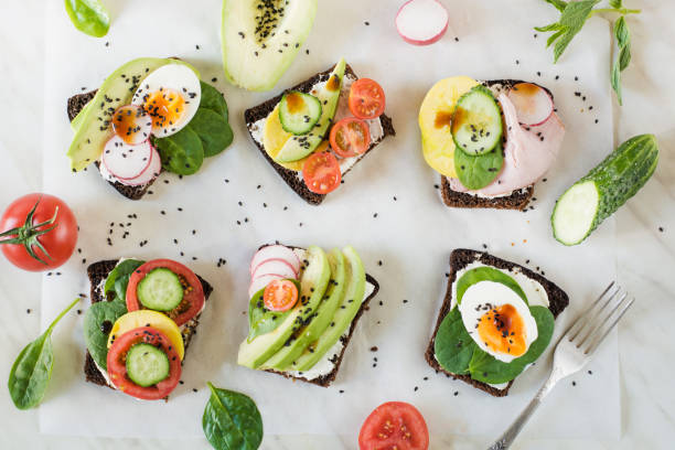 istock Different sandwiches with vegetables, eggs, avocado, tomato, rye bread on light marble table. Top view. Appetizer for party. Flat lay. 961805764