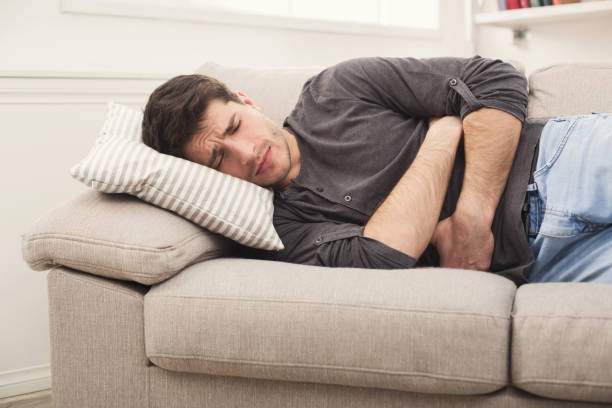 istock Young man having stomachache at home 961811866