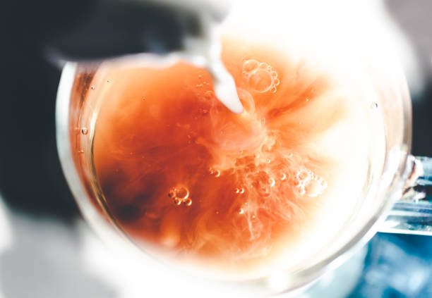 a nice warm cup of tea, shot in a studio, milk swirls in tea - chá gelado imagens e fotografias de stock