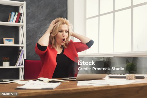 istock Shocked businesswoman working on laptop at office 961817752