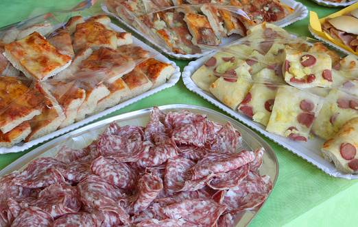 many trays with foods like pizza salami