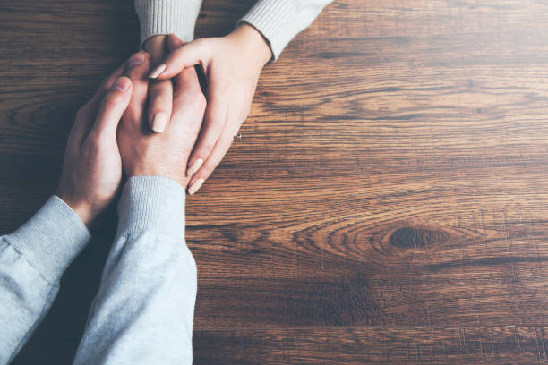 istock Closeup on two young lovers holding hands at a table 961824568