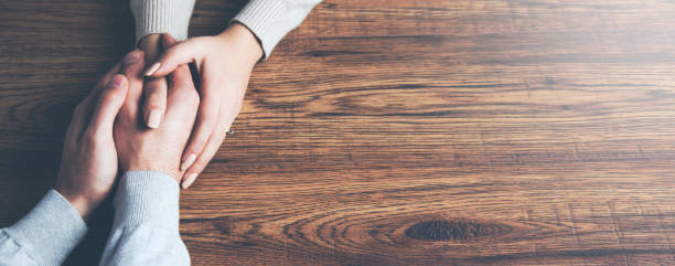 istock Closeup on two young lovers holding hands at a table 961826476