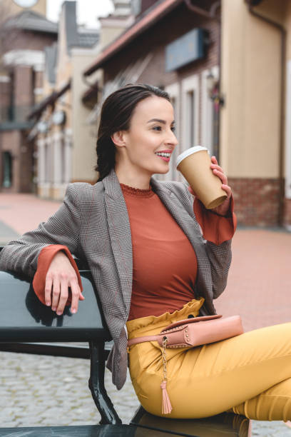 istock beautiful stylish woman drinking coffee from disposable coffee cup 961829998