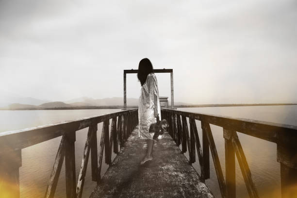 istock woman standing at water level gate, horror scene in white tone 961833192