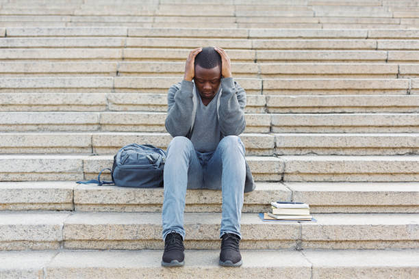 istock Stressed african-american man sitting on stairs 961833858
