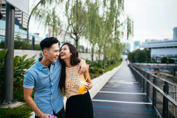 Couple enjoy drinking juice by the Klang river Young couple enjoy walking by the Klang river and drinking juice in Kuala Lumpur, Malaysia chinese couple stock pictures, royalty-free photos & images