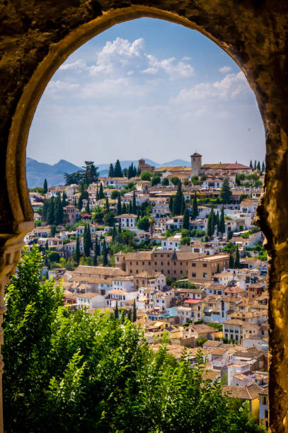 vecchia granada vista da una finestra ad arco nell'alhambra - andalusia foto e immagini stock