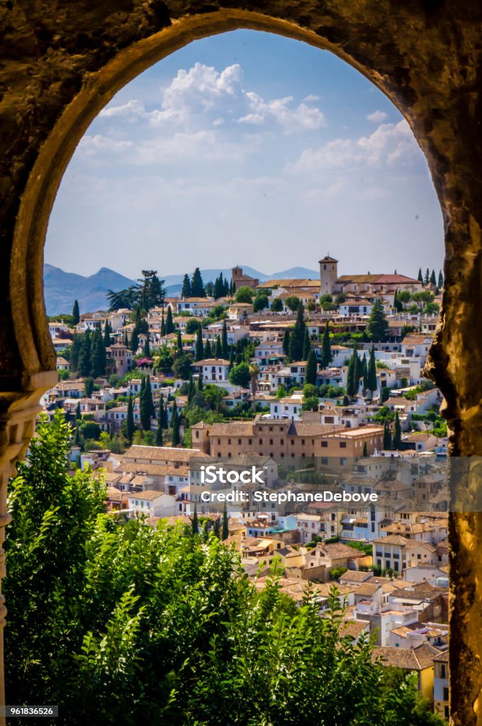 Old Granada seen from an arched window in the Alhambra Old town of Granada seen from an arched window in the Alhambra Granada - Spain Stock Photo