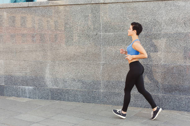 istock Young woman running in city copy space 961841674