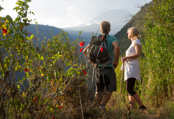 Couple hiking below volcano in forest