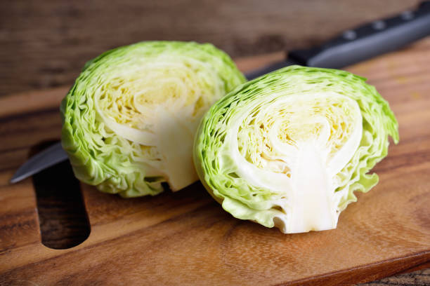 istock half cut fresh cabbage with knife on wooden cutting board 961851228