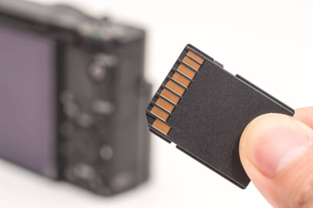 istock male hand holding sd memory card. Isolated on white background 961851960