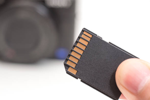istock male hand holding sd memory card. Isolated on white background 961852080