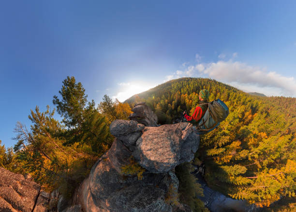 istock Backpacker on top of a rock fall at dawn. Wide angle aerial panorama 961852764