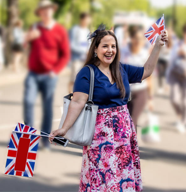 istock Happy young woman waving union Jack flags 961853232
