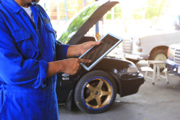 istock Car mechanic holding digital tablet in auto repair service. 961853662