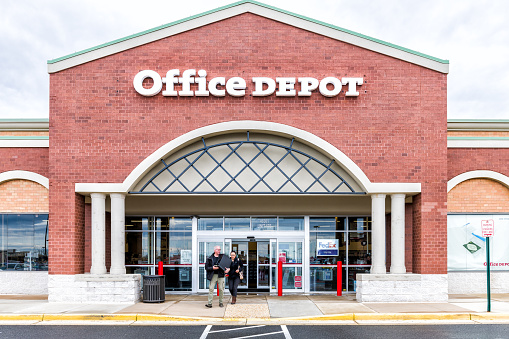Sterling, USA - April 4, 2018: Office Depot store in Fairfax county, Virginia shop exterior entrance with sign, logo, doors , couple walking out
