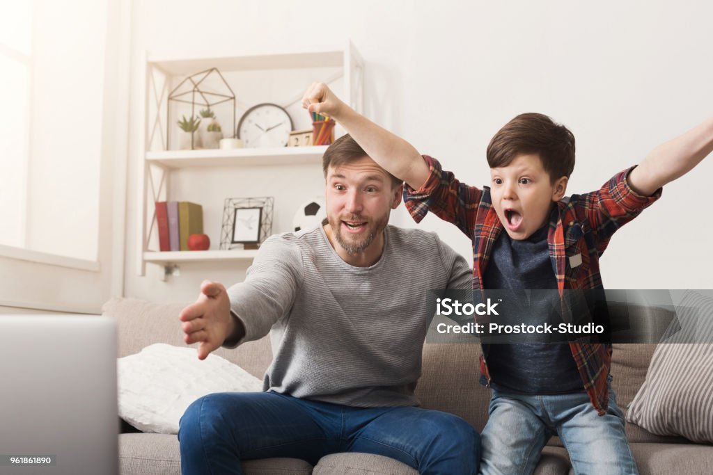 Pai e filho assistindo futebol na TV em casa - Foto de stock de Futebol royalty-free