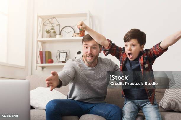 Foto de Pai E Filho Assistindo Futebol Na Tv Em Casa e mais fotos de stock de Futebol - Futebol, Assistindo, Família