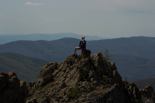 istock Young woman hiker standing on top of a cliff , with backpack 961870722