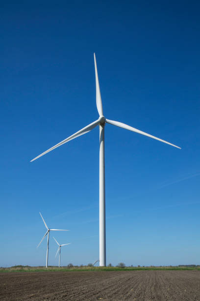 istock Wind energy turbines on sunset sky background, Energy generator nature friendly. Spring field. 961871402