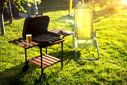 Grill leaned, glass full of bear and everything is ready for a beautiful picnic on a sunny day.