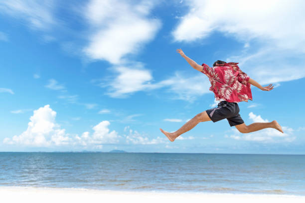 istock Athletic young man enjoying the summer, jumping in a tropical beach.  Summer Concept 961876444