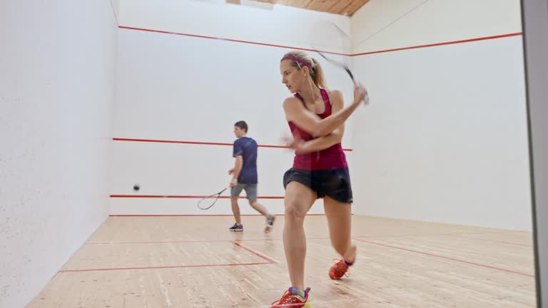 DS Young man and woman playing squash