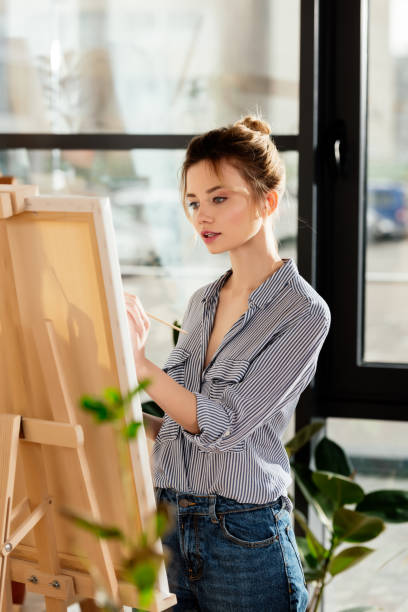 istock young attractive female artist drawing picture in studio 961881476