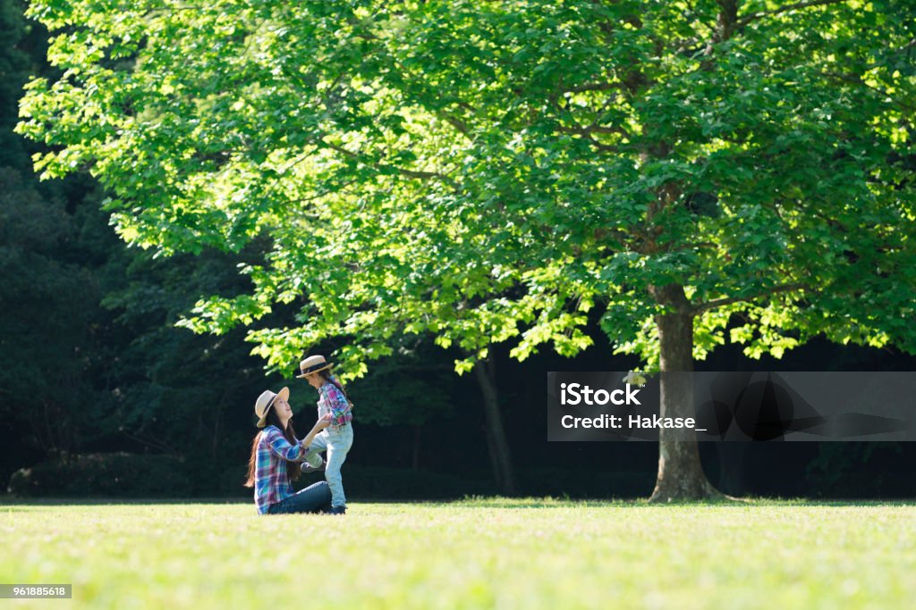 Madre e hija jugando en prado - Foto de stock de Parque público libre de derechos