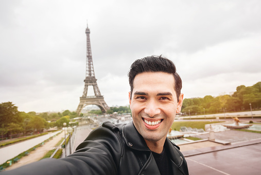 Young man taking selfie with smartphone in Paris