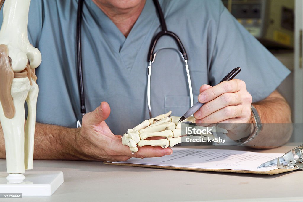 doctor mirando una junta de mano - Foto de stock de Anatomista libre de derechos