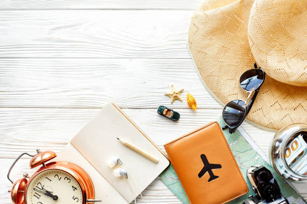 istock time to travel concept, space for text. map camera passport money phone with empty screen sunglasses and clock hat shells car toy on white wooden background. hello holiday, planning vacation 961901912