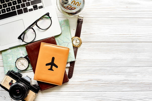 istock travel and wanderlust concept, planning summer vacation background flat lay, space for text. map compass photo camera glasses wallet money watch laptop on white wooden table top view 961902044