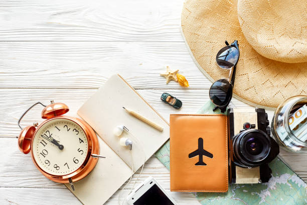 istock time to travel concept, space for text. map camera passport money phone with empty screen sunglasses and clock hat shells car toy on white wooden background. hello holiday, planning vacation 961902888
